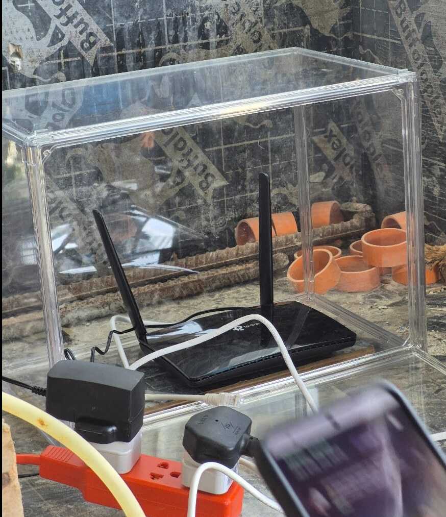 TP-Link Archer MR402 router protected inside a clear construction-site enclosure